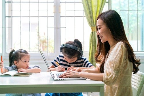 Seorang ibu tampak kelelahan karena bekerja sekaligus mengasuh anak. 